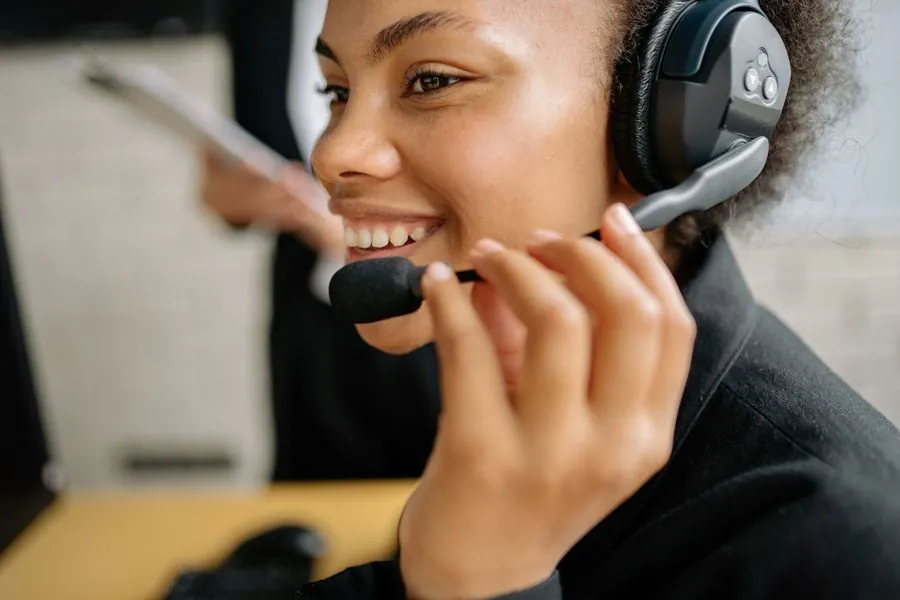 Technicien Helpers souriant, avec son casque, en ligne avec une cliente